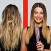 A split image showing a woman's hair before and after using a hair straightener. The woman on the right is smiling and holding the hair straightener. Anteprima dell’immagine prodotto