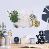 A desk setup with decorative hexagonal mirrors on the wall, plants, and office supplies. Produktbild-Vorschau