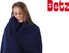 A woman wrapped in a dark blue blanket, with her eyes closed. Produktbild-Vorschau