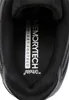 A close-up view of the inside of a black shoe, showing the insole with branding. Voir les images du produit
