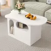 A white, cloud-shaped coffee table with books and oranges on it, placed on a carpet in a living room. Produktbild-Vorschau