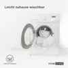 A washing machine with its door open, showing laundry inside, with text overlay and a laundry symbol. Voir les images du produit
