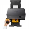 A hand holds a smartphone displaying a photo, in front of a Canon Pixma printer that is printing a photo. Náhled obrázku produktu