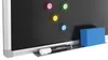 A close-up of a magnetic blackboard with colorful magnets, a marker, and an eraser. Produktbild-Vorschau