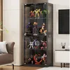 A tall, modern glass display cabinet filled with various action figures and collectibles, placed in a living room setting next to a sofa and a TV stand. Náhľad obrázku produktu