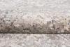 A close-up view of a rolled-up rug with a textured, abstract pattern in shades of gray and cream. Anteprima dell’immagine prodotto