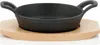 A cast iron serving pan with a wooden base on a white background. Produktbild-Vorschau