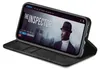 A black flip-case wallet for an iPhone is shown open, displaying the phone's screen which shows a movie poster for 'The Inspector'. Produktbild-Vorschau
