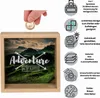 A wooden money box with a landscape image and text 'Adventure Awaits' on the front, with a hand inserting a coin from the top. To the right are icons and text describing the product's features. Produktbild-Vorschau