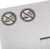 Close-up of two safety warning symbols etched onto a brushed metal surface. Voir les images du produit