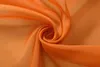 A close-up shot of draped orange sheer fabric, creating a swirl pattern. Produktbild-Vorschau