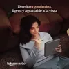 A woman is sitting on a couch, holding an e-reader and a stylus. Produktbild-Vorschau