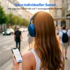 A woman wearing blue headphones is looking at her phone while walking on a street. Produktbild-Vorschau