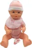 A baby doll wearing a pink hat and bib, sitting with its legs spread. Produktbild-Vorschau