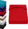 A stack of colorful fitted sheets is shown on the left, and a single red fitted sheet is displayed prominently on the right. Produktbild-Vorschau