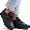 A person wearing ripped jeans and black sneakers. Produktbild-Vorschau