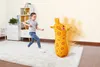 A young girl is playing with an inflatable giraffe punching bag in a room. Produktbild-Vorschau