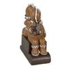 A decorative gingerbread man figurine sitting on a sled. Produktbild-Vorschau