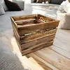 A wooden crate is placed on a wooden floor in a room with soft furnishings. Anteprima dell’immagine prodotto