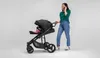 A woman is pushing a stroller while talking on her phone. Anteprima dell’immagine prodotto