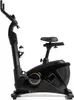 A black stationary exercise bike with gold accents, shown from the side against a white background. Produktbild-Vorschau