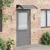 A gray door with a clear polycarbonate awning above it, mounted on a brick wall. Náhľad obrázku produktu