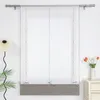 A window with a sheer gray and white roman shade, decorated with small bows, is shown in a room with a lamp and a vase of flowers on a nightstand. Produktbild-Vorschau