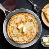 A close-up view of a stack of pancakes with butter on top, in a pan. Voir les images du produit