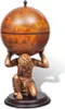 A globe bar supported by a statue of Atlas on a wooden base, set against a white background. Voir les images du produit