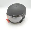 A black matte ski helmet with a silver visor is shown against a white background. Anteprima dell’immagine prodotto