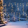 Outdoor winter scene with snow-covered trees and bushes, decorated with warm white icicle lights. Náhled obrázku produktu