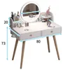 A white vanity table with a round mirror and wooden legs, featuring various cosmetic products and dimensions indicated by measurement lines and numbers. Podgląd zdjęcia produktu