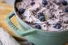 A close-up view of a sage green Staub pot filled with blueberry lavender ice cream. Produktbild-Vorschau