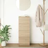 A tall, narrow wooden cabinet with three drawers is shown in a room with a plant, a mirror, and a coat rack. Podgląd zdjęcia produktu