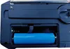 Close-up of a battery compartment on a black electronic device, showing a blue battery inside. Produktbild-Vorschau