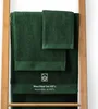 Several dark green towels are folded and displayed on a wooden rack. Produktbild-Vorschau