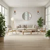 A modern living room with a sofa, chairs, coffee table, and a round mirror on the wall. Produktbild-Vorschau