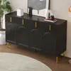 A black sideboard with gold handles and legs, placed on a wooden floor with a round rug in front of it. Decorative items are on top of the sideboard. Anteprima dell’immagine prodotto