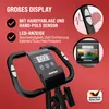 Close-up of the handlebars and display of a stationary bike, with marketing text and feature callouts. Produktbild-Vorschau