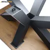 A close-up view of a metal table base with a wooden tabletop. Voir les images du produit