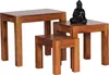 A set of three wooden side tables of varying sizes, with a small black Buddha statue on the largest table.