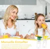 A mother and daughter are sitting at a table, eating cereal and drinking juice. The daughter is drinking from a glass of orange juice. There are two manual juicers in the foreground. Produktbild-Vorschau