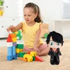 A young girl plays with colorful building blocks next to a Harry Potter plush toy. Anteprima dell’immagine prodotto