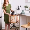 A woman is placing a small appliance into a tote bag in a kitchen setting. Anteprima dell’immagine prodotto
