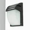 A black outdoor wall light with a frosted glass diffuser, mounted on a white wall. Produktbild-Vorschau