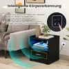 A black nightstand with LED lighting and USB ports is shown next to a sofa, with graphics indicating motion detection features. Náhled obrázku produktu