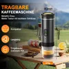 A portable coffee machine is displayed on a wooden table outdoors, with a scenic background of hills and trees. Other items like a can, cookies, and a lemon are also present. Produktbild-Vorschau