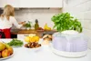A woman is preparing food in a kitchen, with a food dehydrator and various ingredients on the counter. Náhľad obrázku produktu