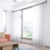 A living room with a large window covered by white sheer curtains. Produktbild-Vorschau