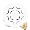 A white pasta maker disc with star-shaped cutouts is shown from a top-down perspective. Several shell-shaped pasta pieces are arranged in the lower right corner of the image. Podgląd zdjęcia produktu